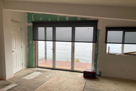 Stylish automatic window treatments installation process in a bright Laguna Beach living area.