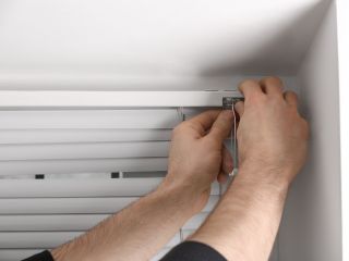 Skilled Technicians Repairing Window Coverings in Laguna Beach A man takes a mesure for blinds installation in Laguna Beach